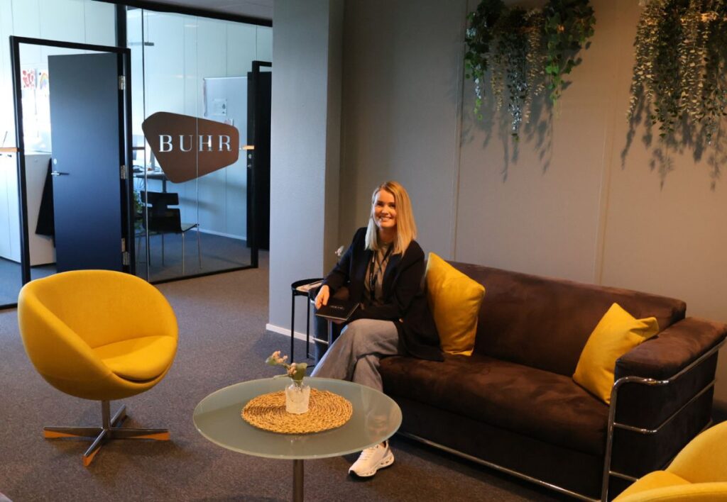 Trine sitter i en sofa